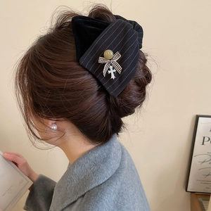 Detailansicht einer Vintage-Haarklammer mit Samtstoff und Kreuzanhänger an einem Model