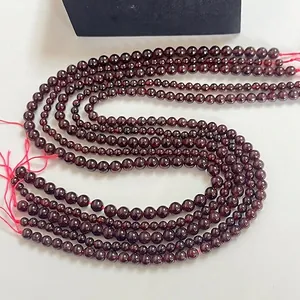 Perles rondes en grenat rouge profond naturel pour bijoux DIY disposées en forme de S