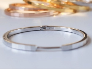 Detailed close-up of S925 sterling silver stamp on minimalist silver bangle bracelet