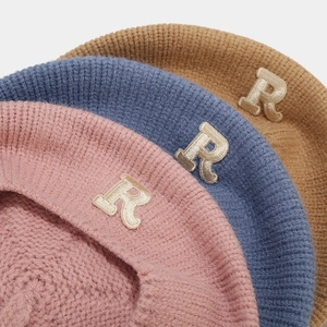 Detailed knit texture of autumn winter beret hats with R-letter patch in various colors