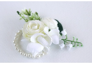 Close-up of elegant white rose wrist corsage with pearls for wedding and bridesmaids