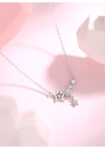 Macro detail of silver star pendants with micro-set zircons on a delicate chain