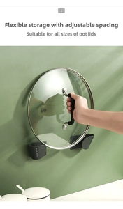 Detail of adjustable black wall-mount pot lid racks holding a glass lid on green wall