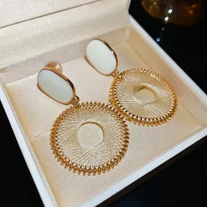 French palace style dreamcatcher earrings with gold circles and white oval details