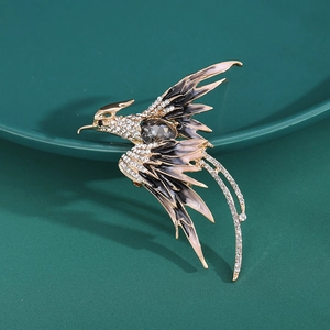 Detailed close-up of elegant phoenix brooch with pink and black enamel and rhinestones