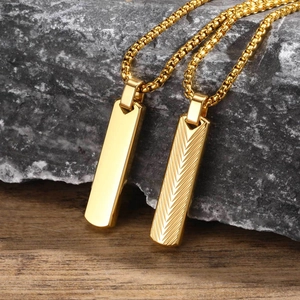 Macro detail of gold stainless steel bar pendants with herringbone texture on grey stone