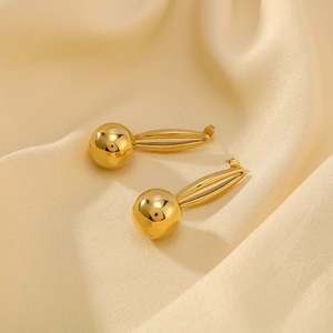 Élégantes boucles d'oreilles boules dorées à double couche sur fond de soie de qualité