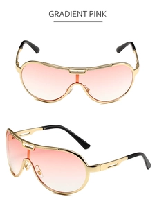Close-up of oversized sunglasses featuring gradient pink lenses and golden metal frame