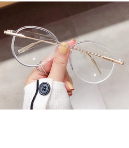 Detailansicht der transparenten runden Brille mit schlanken goldenen Metallbügeln
