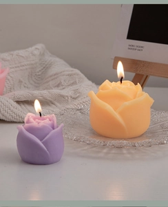 Macro shot of purple and yellow rose scented candles on a cozy white knitted blanket