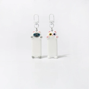 Close-up of Siamese and white cat keychains with heterochromia eyes and metal clasps