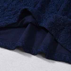 Close-up of intricate navy blue lace texture and premium stitching on the dress