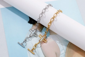 Detailed view of silver and gold cross bracelets with pavé crystals and OT toggle clasp