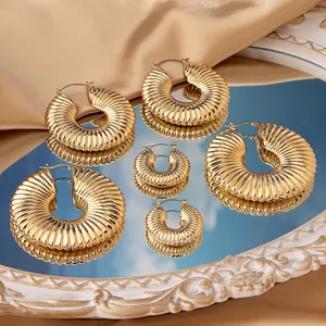 Set of six premium ribbed gold hoop earrings in various sizes on a silk background