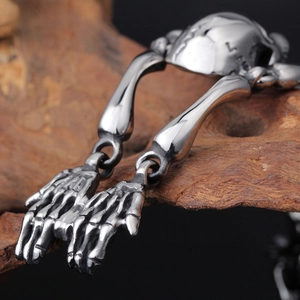 Detailed close-up of gothic skull and bone hand links on a vintage steel bracelet