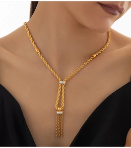 Gros plan du collier tressé doré avec pendentif à franges et détails en strass sur un mannequin