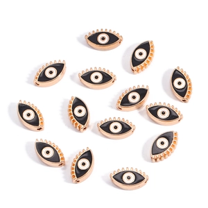 Macro view of 10mm golden devil eye charms with enamel finish and side drill holes