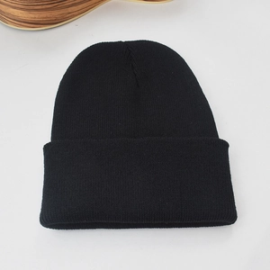 Gros plan sur la texture en maille fine et le tissu noir de ce bonnet d'hiver chaud