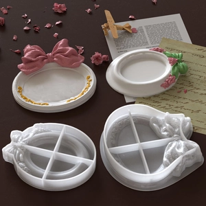 Detail of oval resin tray mold set showing white bow frame and finished DIY plaster crafts