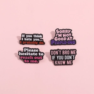 Set of four black enamel pins with funny English quotes on a pastel pink background