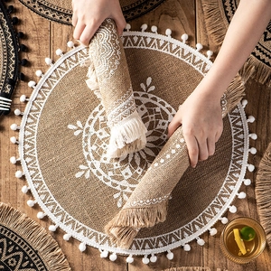 Handcrafted round jute placemat with white lace pattern, fringes and tassels decor