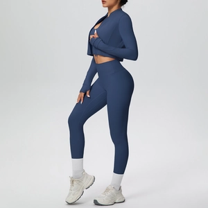 Dettaglio del set yoga blu scuro con giacca con fori per i pollici e leggings a vita alta