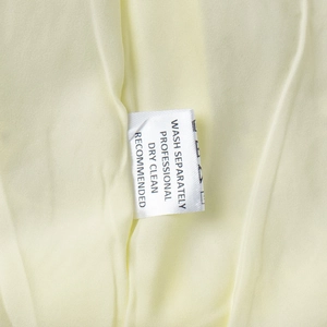 Detail of fabric lining and care label with washing instructions for the cotton dress