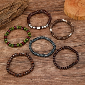 Close-up of six handmade multi-layer elastic wooden bead bracelets on a natural wood surface