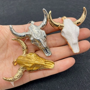 Detailed view of large bull skull shaped resin and metal pendants for DIY necklace design