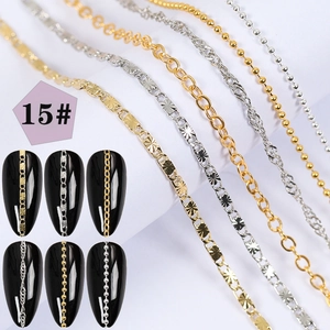 Detail of silver and gold nail art chains with pearls and rhinestones on black tips