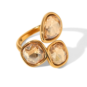 Golden cocktail ring featuring champagne pear and cushion cut zircons on white background