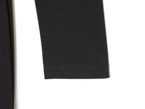 Detail der Doppelnadelnaht und Strickgewebestruktur an einem schwarzen V-Ausschnitt-Kleid