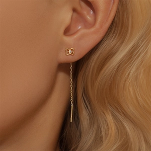 Detailed close-up of a golden tassel earring featuring a star pendant and zircon stones