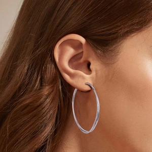 Close-up of model wearing large S925 sterling silver hoop earrings with subtle crystals