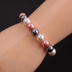 Detail von grauen, rosa und weißen runden Muschelperlen, aufgereiht in ein Perlenarmband