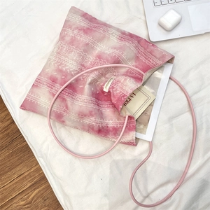 Close-up of pink tie-dye canvas tote bag with lace prints and slim shoulder straps