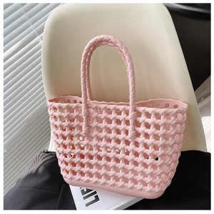 Detailed view of pink woven hollow-out basket bag with handles on a white chair