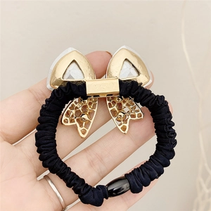 Elegant black high-elastic hair tie with gold crystal bow ornament held by hand