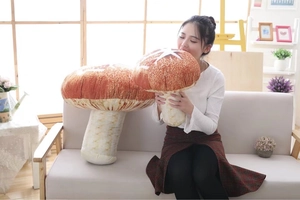 Detail of soft plush mushroom pillows in medium and large sizes on a sofa
