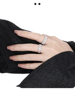 Detail of S925 sterling silver ring with brushed texture and blue gemstone on a model