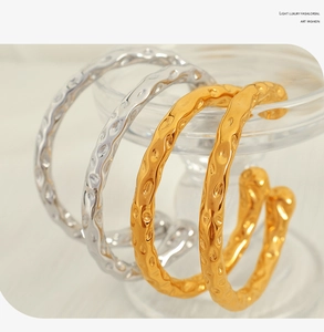 Detailed macro shot of the hammered texture on gold and silver stainless steel cuff bangles