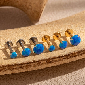 Detailed view of six flat back opal labret studs in silver and gold steel settings
