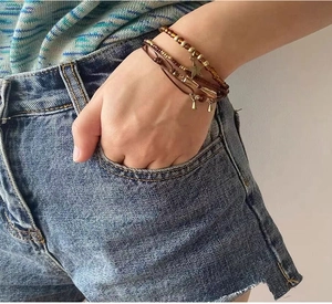 Détail d'un bracelet multicouche bohème avec breloques étoiles au poignet d'une femme