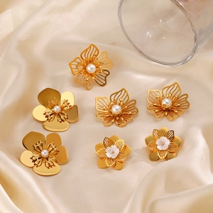 Chic gold flower earrings and studs set with white pearls on champagne silk fabric