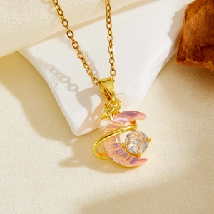 Detail of gold star and moon necklace with pink gradient pendant and zircon on white stone