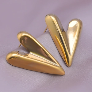 Macro shot of 18K gold plated 304 stainless steel heart stud earrings on silk fabric