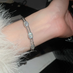 Macro detail of silver zircon hollow buckle bracelet on wrist with elegant fur cuff