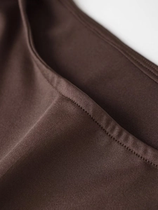 Detailed close-up of dark brown knitted fabric texture and fine double-stitched hem