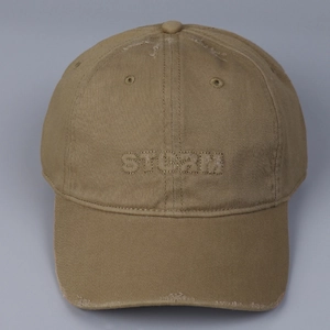 Close-up of distressed cotton baseball cap with STORM embroidery and frayed details