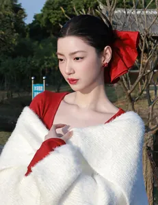 Detail of red flower zircon stud earrings and bow hair clip on model in festive winter setting